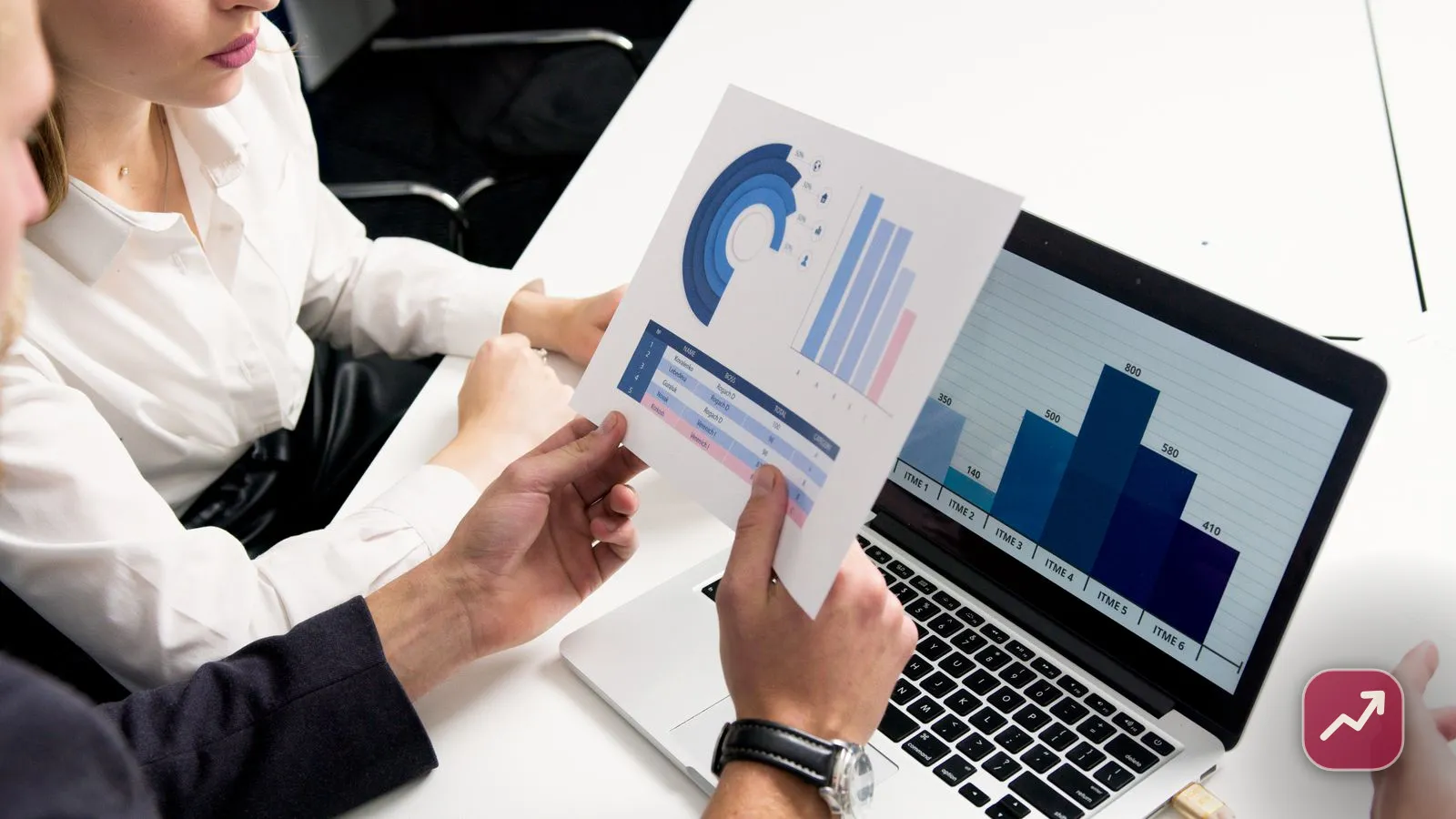 Deux personnes examinent des graphiques d’investissement sur un ordinateur portable, illustrant l’investissement en dividendes et leur fiscalité.