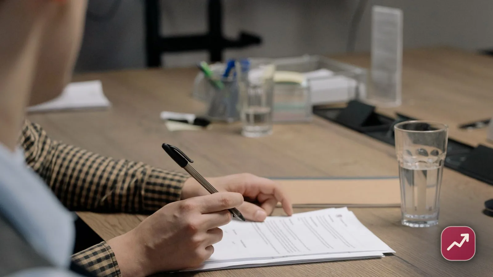An adult reviewing a deceased relative’s bills and paperwork at a table, illustrating whether you inherit debt when someone dies.