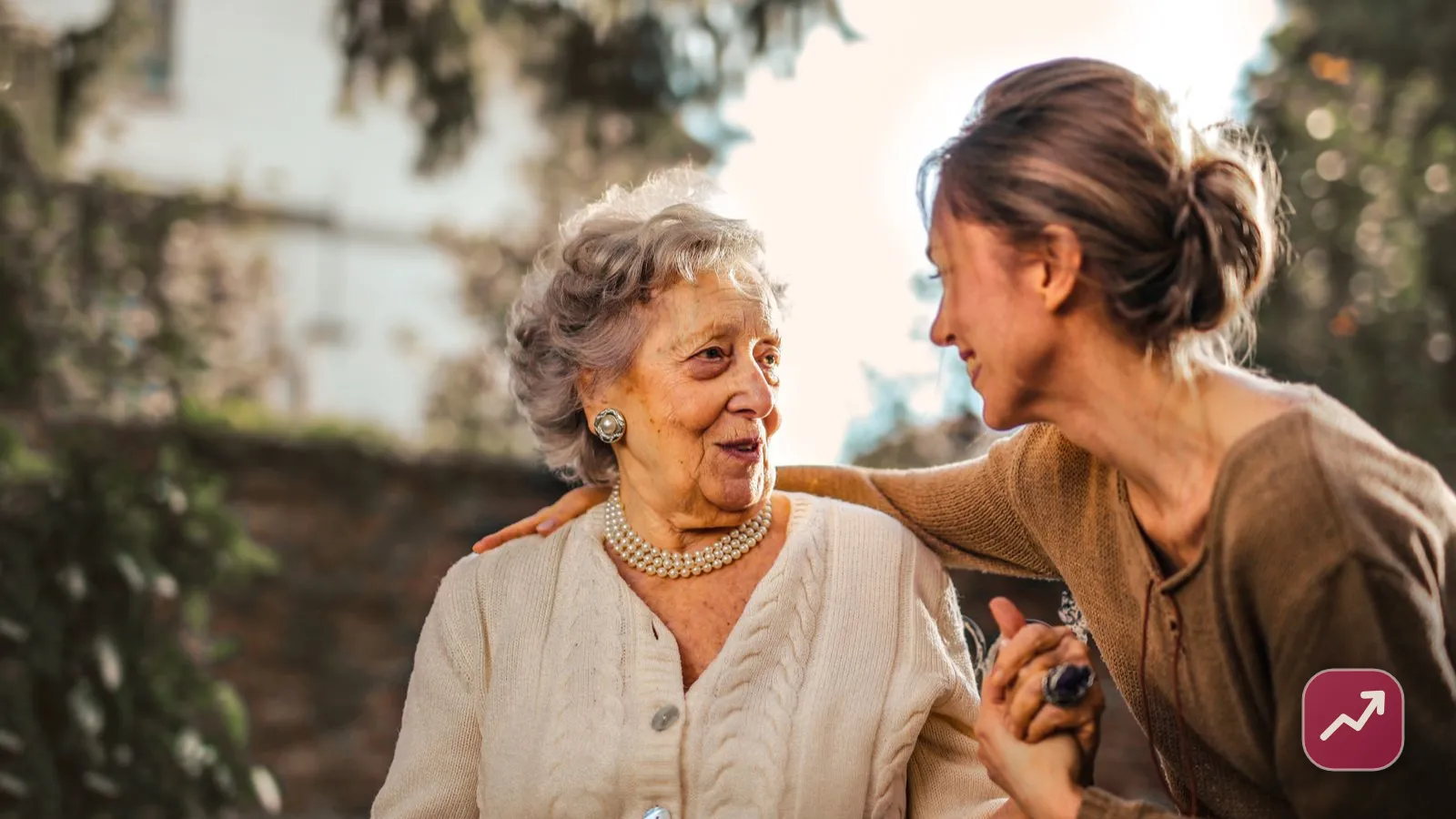 Two generations of a family, an older mother and her adult daughter, smiling together outdoors, illustrating how gift tax works when giving money to family.