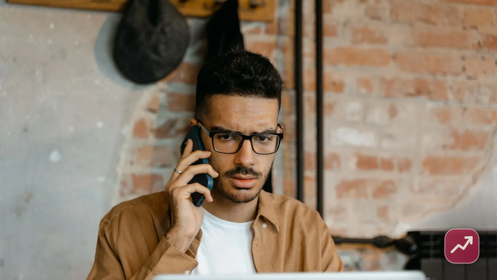Une personne vérifiant attentivement son téléphone à côté d’un ordinateur portable, illustrant comment se protéger des arnaques financières.