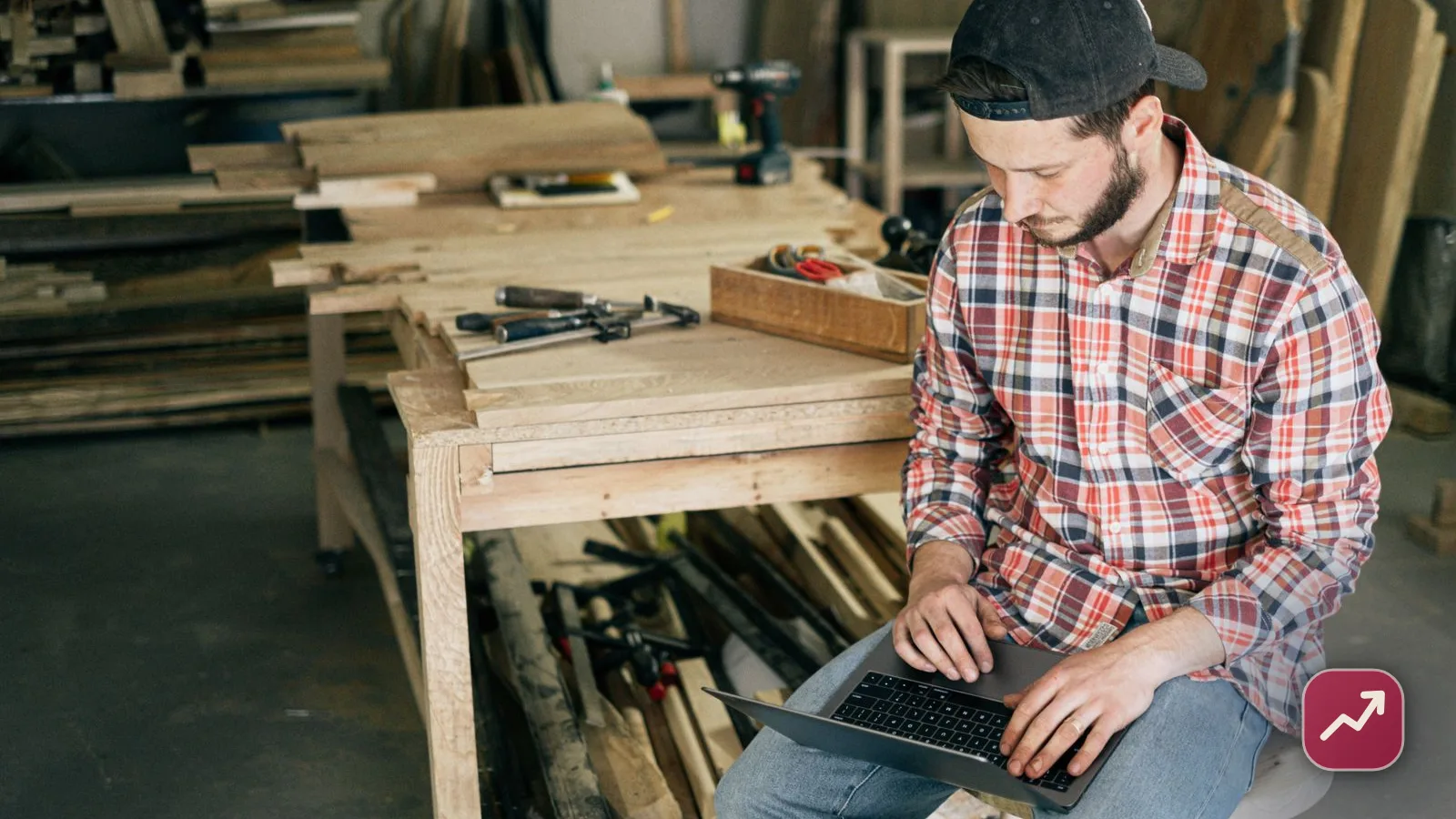 A small business owner working on a laptop in their workshop, illustrating how to get a business loan when you are self-employed.