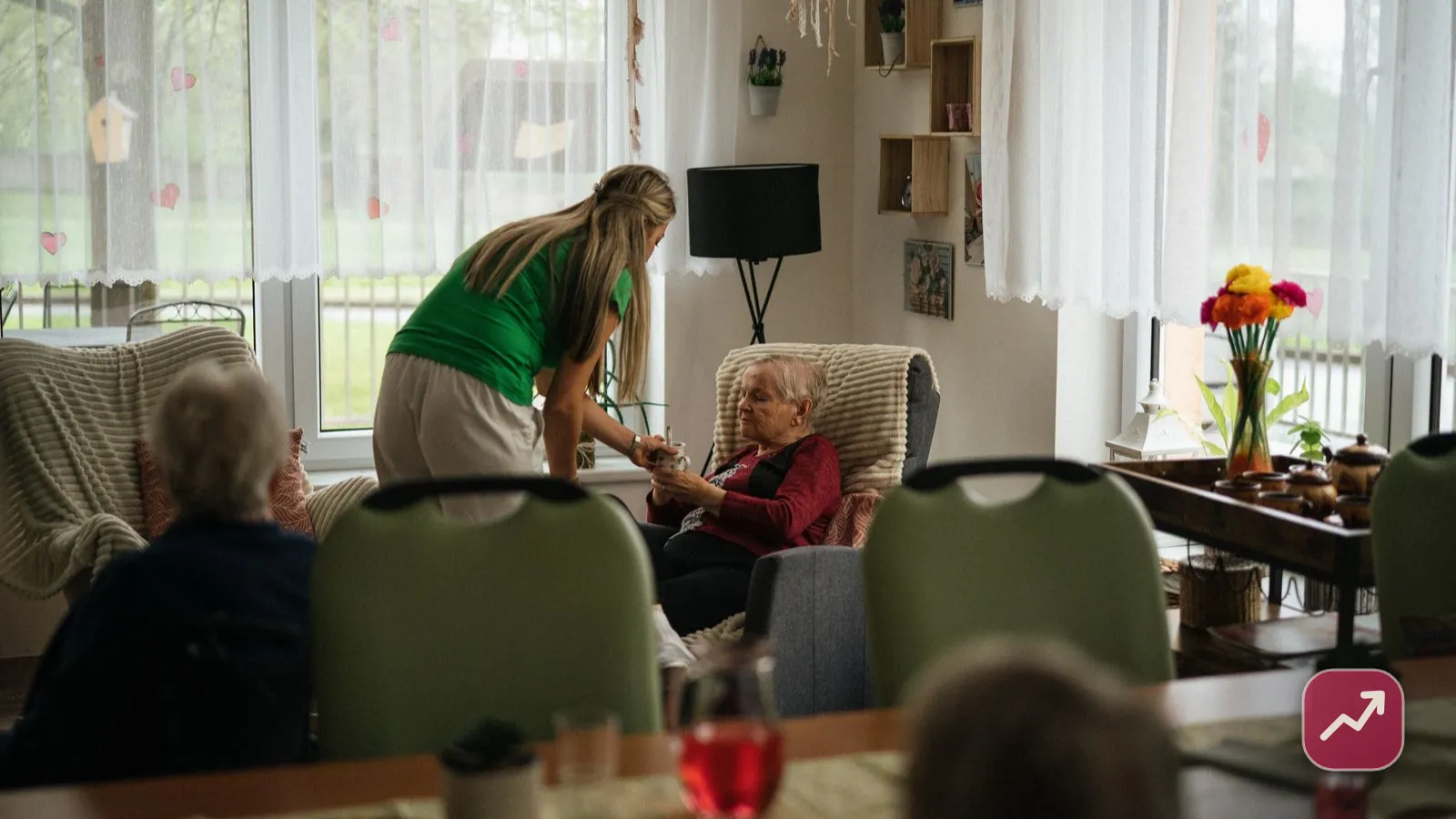 Une aide-soignante s’occupe d’une femme âgée dans une maison de retraite, illustrant comment financer la dépendance et l’EHPAD.
