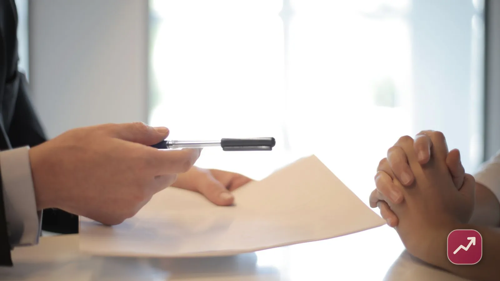 Deux personnes signent un accord juridique avec un stylo sur un bureau, illustrant comment fonctionne le contrat de mariage et le régime matrimonial.