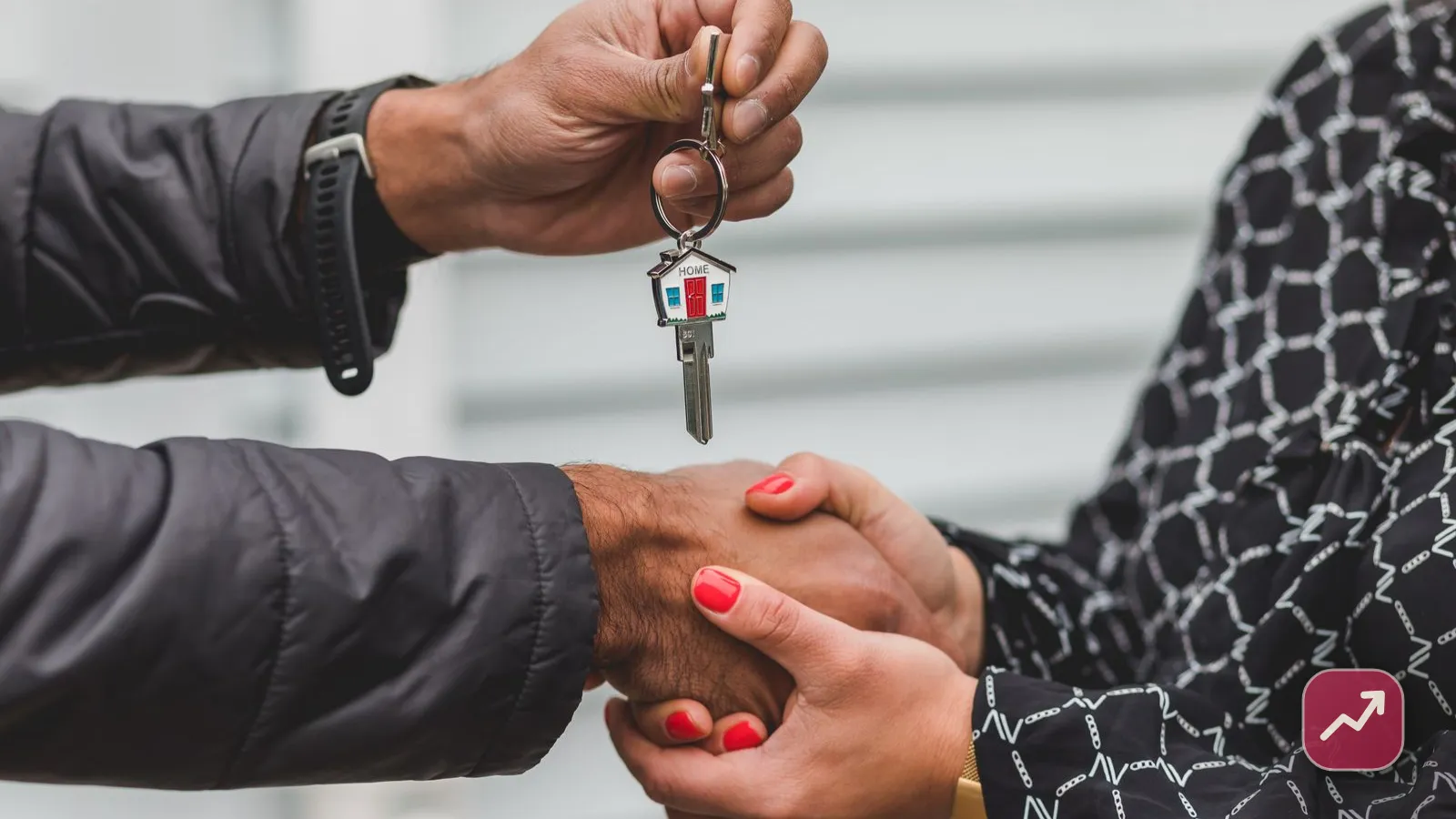 One person handing over the keys to a house to another after a sale, illustrating capital gains tax when you sell your home.