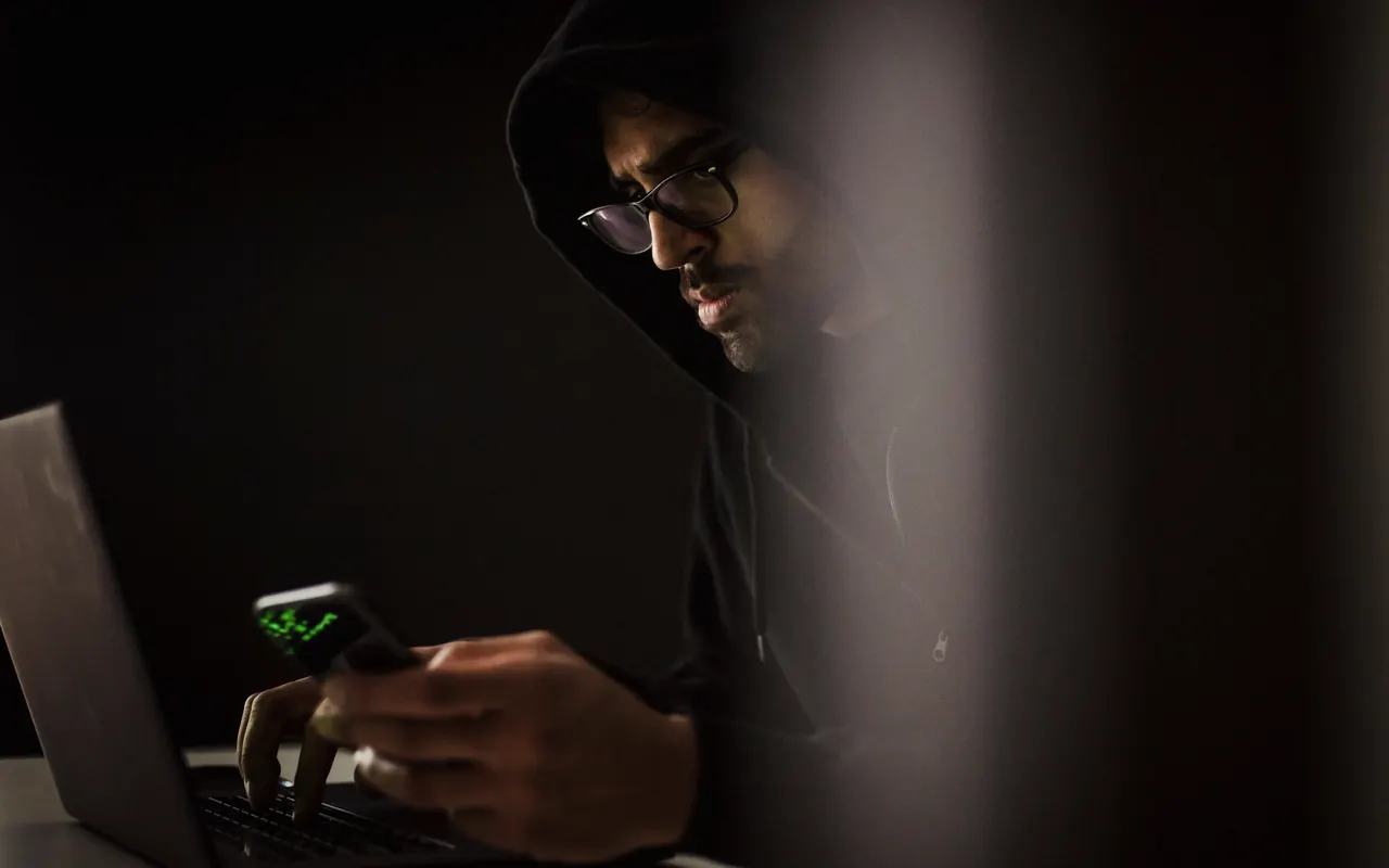 Persona sujetando un móvil con un aviso de seguridad en la pantalla