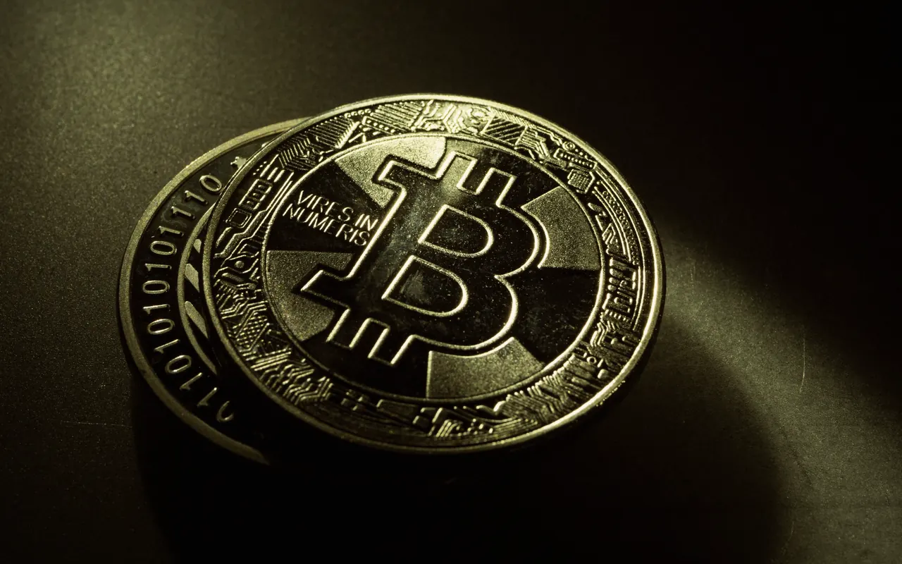 Primer plano de una moneda dorada con el símbolo de Bitcoin sobre fondo oscuro