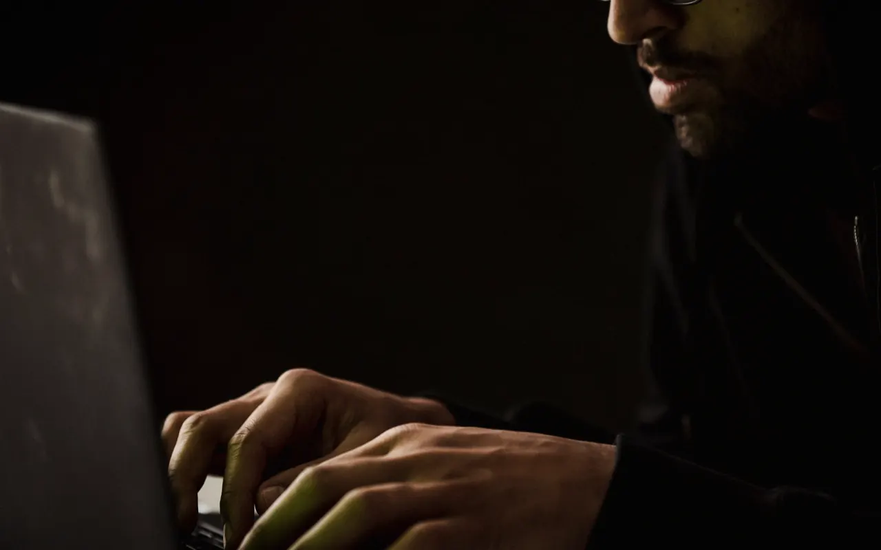 Persona viendo un vídeo en un portátil sobre un escritorio, de noche